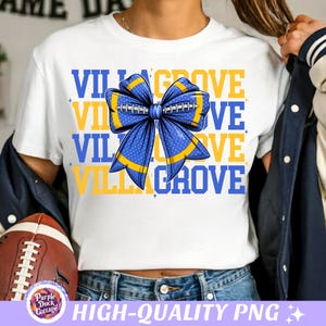 May include: White t-shirt with the text "VILLAGROVE" in blue and yellow. A blue bow with yellow accents, resembling a football, is centered on the shirt. The shirt is part of a sports-themed collection.