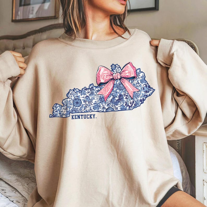 Kentucky state outline with blue and white Chinoiserie floral pattern and pink coquette bow PNG design.