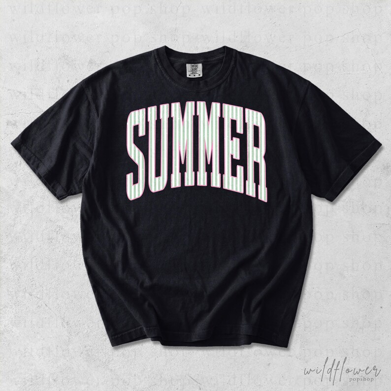 May include: Black t-shirt with the word "SUMMER" in large, white, arched letters. The letters are filled with thin, vertical stripes of light green and pink. The shirt has short sleeves.