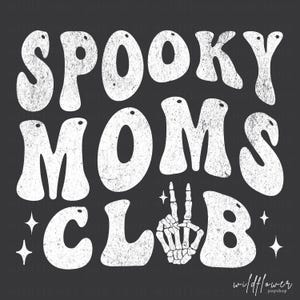May include: A graphic design featuring the white distressed text SPOOKY MOMS CLUB on a dark gray background. The letter U in CLUB is replaced by a white skeletal hand making a peace sign. Four small white four-pointed stars surround the text.