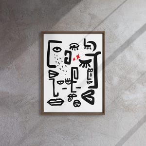 May include: A framed black and white abstract art print with a white background and black line drawings of eyes, lips, and other facial features. There are two red stars in the center of the print.
