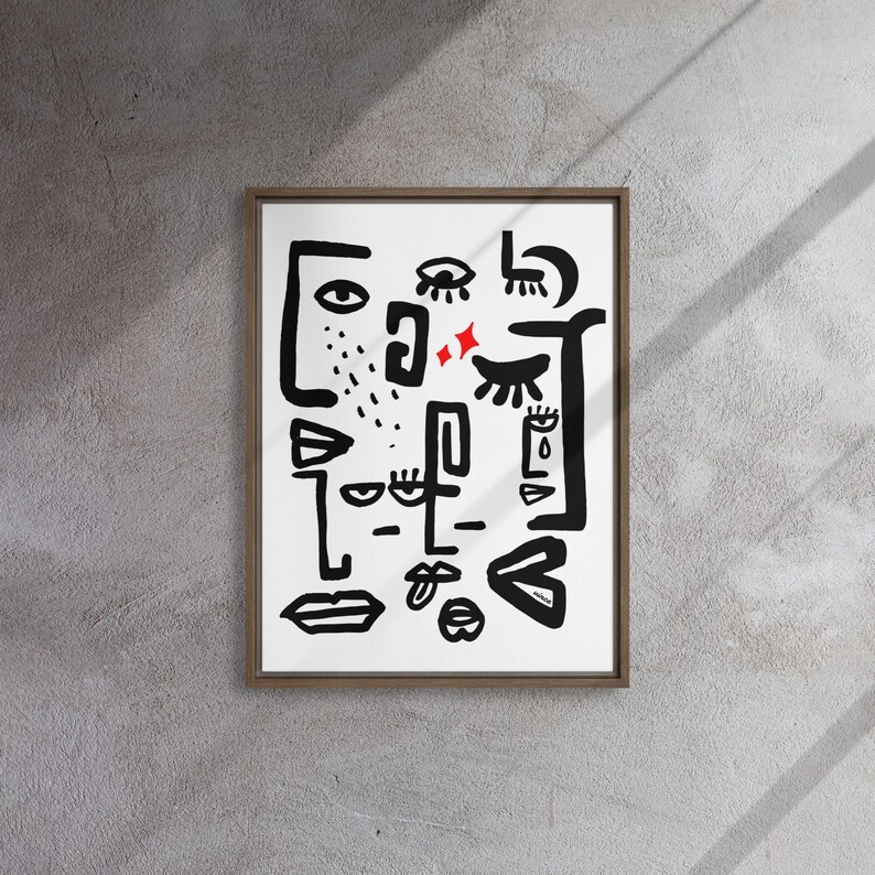May include: A framed black and white abstract art print with a white background and black line drawings of eyes, lips, and other facial features. There are two red stars in the center of the print.