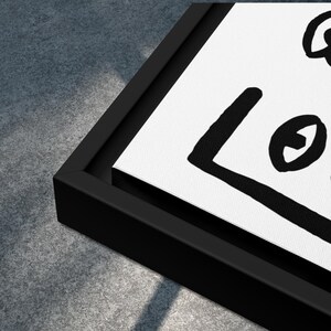 May include: Black and white framed canvas print with a simple abstract design featuring a square and circles.
