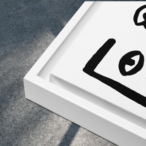 May include: A white canvas print with a black and white abstract design. The design features a large square with a circle inside and a smaller circle outside the square.