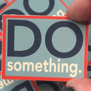 Peut inclure: Un autocollant carré avec une bordure rouge et les mots "DO something." en blanc et bleu marine. L'autocollant est tenu par une main, avec d'autres autocollants similaires en arrière-plan. Les autocollants d'arrière-plan ont le mot "something" visible.