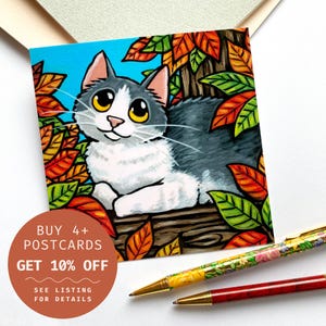 Carte postale chat d'automne - Chat gris et blanc entouré de feuilles d'automne vibrantes en vert orange jaune, carte postale illustrée, carré