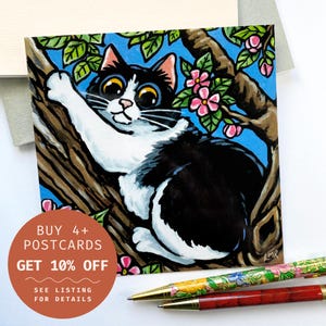Carte postale chat espiègle dans un arbre – Chat noir et blanc avec des fleurs roses, art de chat espiègle, carte postale carrée