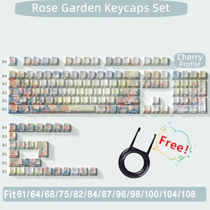 May include: A set of rose garden themed keycaps for a mechanical keyboard. The keycaps feature a watercolor-style design with pink roses and green leaves on a light blue background. The keycaps are labeled with the letters R1, R2, R3, and R4, indicating the rows of the keyboard. The keycaps are compatible with 61, 64, 68, 75, 82, 84, 87, 96, 98, 100, 104, and 108 key mechanical keyboards. The text "Cherry Profile" is visible in the image. The image also includes a free keycap puller.