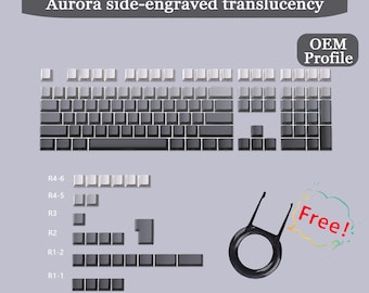 Op de afbeelding: Een set grijze toetsenbordtoetsen met aan de zijkant gegraveerde doorschijnendheid. De afbeelding toont de OEM-profieltoetsen, met een keycap-trekker en de tekst "Free!". De keycaps passen op 61/64/68/75/82/84/87/96/98/100/104/108 toetsenborden.