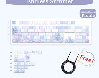 May include: A white keyboard with keycaps featuring a floral design in shades of blue, purple, and pink. The text "Endless Summer" is above the keyboard. Includes a keycap puller and text that says "Free!"