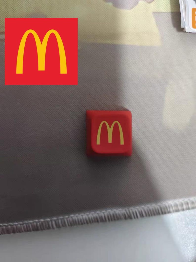 May include: A red square with a yellow "M" logo. The logo is the same as the McDonald's logo.