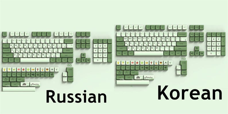 May include: A set of green and white keyboard keycaps with the words "Russian" and "Korean" printed below. The keycaps are arranged in two rows, with the Russian keycaps on the left and the Korean keycaps on the right.
