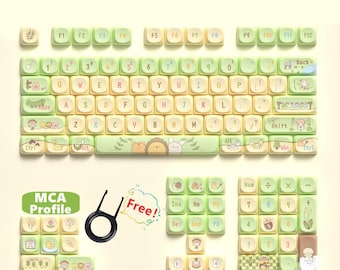 Puede incluir: Un juego de teclas con temática de cuento de hadas del bosque. Las teclas son de color verde claro y crema, con ilustraciones caprichosas de animales y plantas. El juego incluye un extractor de teclas y es compatible con varios tamaños de teclado.