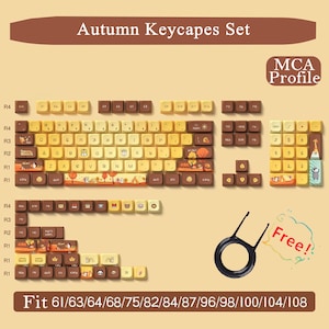 May include: An "Autumn Keycapes Set" with a variety of keycaps in shades of brown, yellow, and beige. The keycaps feature autumn-themed designs and are compatible with various keyboard sizes. Includes a keycap puller.
