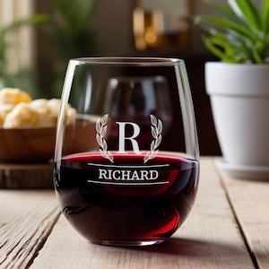 Peut inclure: Un verre &agrave; vin sans pied avec un design personnalis&eacute;. Le verre est rempli de vin rouge et pr&eacute;sente une initiale "R" grav&eacute;e en blanc avec une couronne de laurier et le nom "RICHARD" en dessous.
