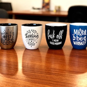 Pu&ograve; includere: Quattro tazze in ceramica con testo umoristico. Una &egrave; argentata con "WORLD'S BEST BOSS", un'altra bianca con "Am Not Feeling Worky Today", una tazza nera con "fuck off I mean good morning" e una tazza blu con "Might be Whiskey".