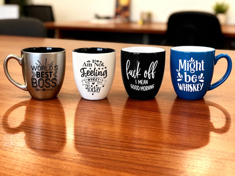 Pu&ograve; includere: Quattro tazze in ceramica con testo umoristico. Una &egrave; argentata con "WORLD'S BEST BOSS", un'altra bianca con "Am Not Feeling Worky Today", una tazza nera con "fuck off I mean good morning" e una tazza blu con "Might be Whiskey".