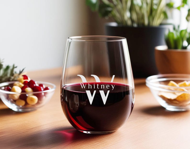 Peut inclure: Un verre &agrave; vin en verre transparent avec un pied, rempli de vin rouge. Le verre porte le nom "Whitney" et les lettres "WW" grav&eacute;es sur le c&ocirc;t&eacute;.