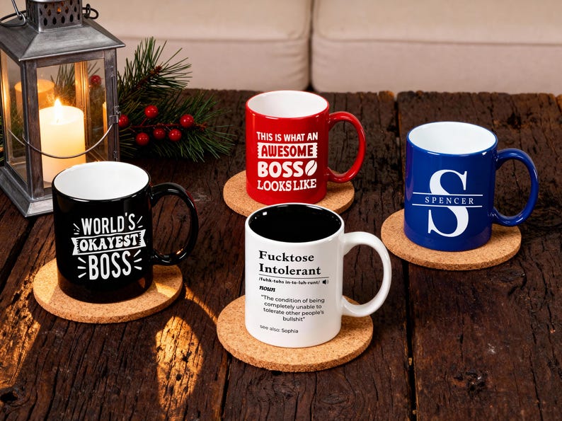 Pu&ograve; includere: Quattro tazze in ceramica con testi e disegni umoristici su sottobicchieri in sughero. Le tazze sono nere, rosse, bianche e blu. La tazza nera dice "World's Okayest Boss". La tazza rossa dice "This is what an Awesome Boss Looks Like."