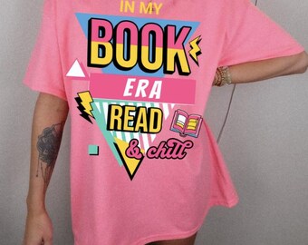 May include: Pink oversized t-shirt with a graphic design featuring a colorful geometric shape with the text "In My Book Era Read & Chill".