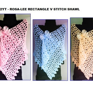 May include: Three crocheted shawls in pink, blue, and peach. Each shawl has a rectangle shape with a V-stitch pattern and a small bow at the neckline. 2232YT - ROSA-LEE RECTANGLE V STITCH SHAWL