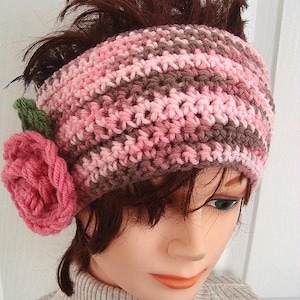 May include: A pink and brown crocheted headband with a pink crocheted flower attached to the side.