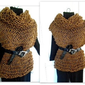 May include: A brown knitted cowl neck sweater with a loose, open weave. The sweater is worn with a black belt and black pants.