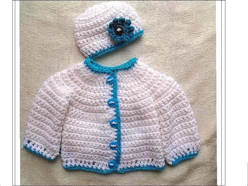 May include: White crocheted baby cardigan with blue trim and buttons. Matching white crocheted hat with a blue flower.