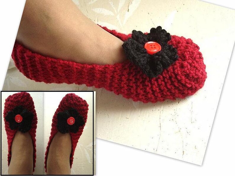 May include: Red knitted slippers with a black flower and a red button. The slippers are shown on a white background.