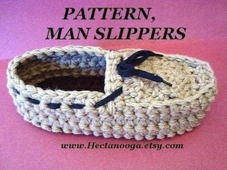 Puede incluir: Una zapatilla de ganchillo beige con detalles y cordones azul oscuro. El texto "PATTERN, MAN SLIPPERS" est&aacute; en la parte superior y "www.Hectanooga.etsy.com" en la inferior. La zapatilla est&aacute; sobre un fondo rosa.