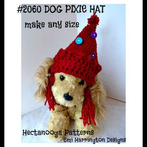 Peut inclure: Un chapeau de lutin en crochet rouge pour chien avec un pompon sur le dessus et des boutons colorés. Le chapeau a de longues franges rouges qui pendent du bord. Le chapeau est sur un petit chien à fourrure brune. Le texte #2060 DOG PIXIE HAT make any size est en haut de l'image. Le texte Hectanooga Patterns Emi Harrington Designs est en bas de l'image.
