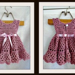 Pu&ograve; includere: Un vestitino da neonata in crochet rosa con un nastro di raso rosa legato in vita. Il vestito ha una chiusura a bottone sul retro.
