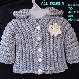 May include: A gray crocheted hooded cardigan with white buttons and a white crocheted flower. The cardigan is available in sizes from newborn to adult 4XL (60 inch chest).