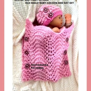 Puede incluir: Un conjunto de capullo y gorro de bebé tejido en un suave tono rosa. El capullo presenta un patrón texturizado en forma de onda y está adornado con botones decorativos. El gorro a juego está adornado con botones similares. El texto "HECTANOOGA PATTERNS" es visible.