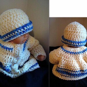May include: A cream-colored, crocheted baby outfit, including a hat and jacket, trimmed with blue yarn. The jacket has a button closure. The hat has a blue band. The outfit is designed for a baby.