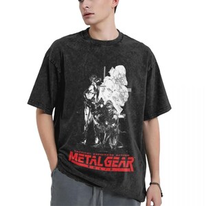 May include: Black t-shirt with a faded, distressed look. The shirt features a graphic print of characters from the video game Metal Gear Solid. The text "Tactical Espionage Action Metal Gear Solid" is printed in red on the front of the shirt.