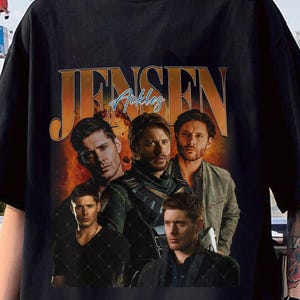 May include: Black t-shirt with a vintage-style graphic of Jensen Ackles. The graphic features a collage of images of Ackles in different roles, including his role as Dean Winchester in the TV show Supernatural.