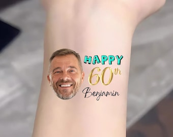 Puede incluir: Un tatuaje temporal con una foto de la cara de un hombre y el texto "Happy 60th Benjamin". El texto está en un esquema de colores azul y dorado.