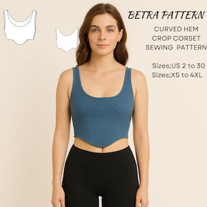 Op de afbeelding: Een vrouw draagt een blauwe crop top en een zwarte legging. De crop top heeft een gebogen zoom en een ronde halslijn. De afbeelding bevat een naaipatroon en de tekst "BETRA PATTERN CURVED HEM CROP CORSET SEWING PATTERN".