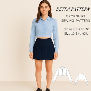 May include: A woman wearing a light blue crop shirt and a navy blue pleated skirt. The image includes the text "BETRA PATTERN CROP SHIRT SEWING PATTERN" and size information. The shirt has long sleeves and a button-down design.