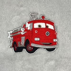 May include: A red fire truck patch with a smiling face, white eyes, and a silver ladder. The patch has black wheels and trim, and is set against a gray background. This embroidered patch is perfect for decorating clothing or accessories.
