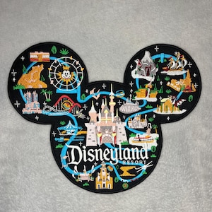 Könnte beinhalten: Schwarzer Mickey Mouse-förmiger Aufnäher mit Disneyland Resort-Design. Der Aufnäher enthält farbenfrohe Illustrationen von Parkattraktionen und das Disneyland Resort-Logo in Weiß und Blau.