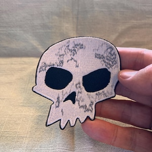 May include: White skull patch with black eye sockets and a distressed, marbled design.