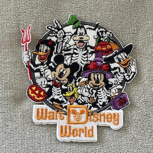 May include: Embroidered patch featuring Disney characters in skeleton costumes, including Mickey Mouse, Donald Duck, and Goofy, celebrating Halloween. The patch has the text "Walt Disney World" in orange and white.