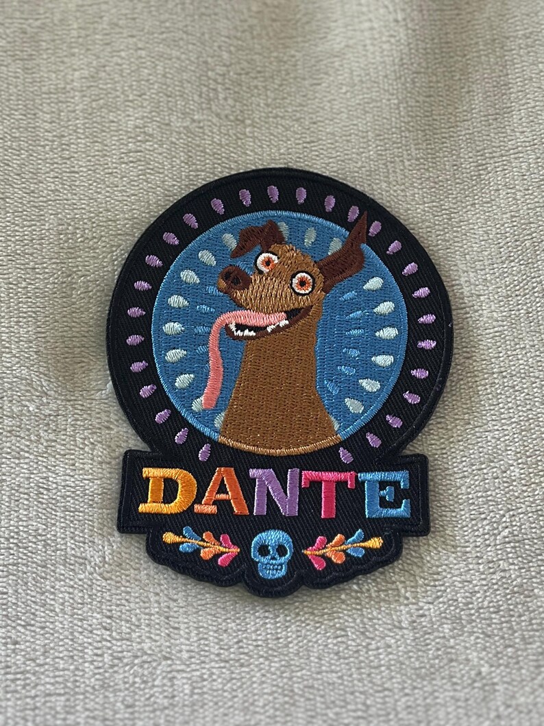Dante patch from Coco with floral design & skull. 4x3 inch embroidered iron-on — perfect Disney Día de los Muertos accent for jackets & bags.