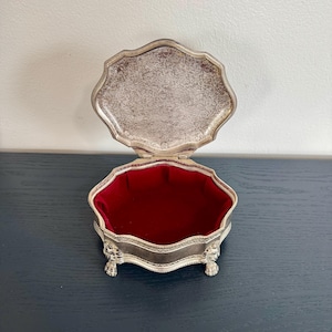 May include: A set of three ceramic canisters with lids. The canisters are white with a blue floral pattern. The largest canister is 8 inches tall, the medium is 6 inches, and the smallest is 4 inches.