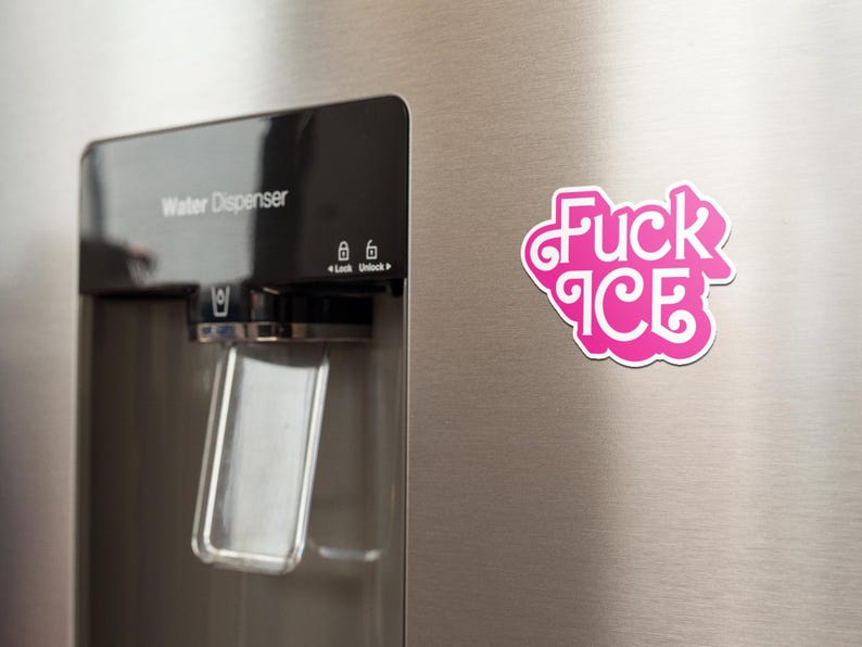 May include: A pink and white magnet with the words "Fuck ICE" in a stylized font is affixed to a stainless steel refrigerator door. The refrigerator has a water dispenser.