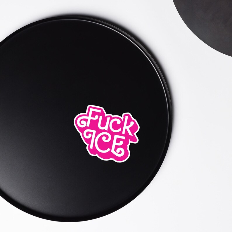 May include: A pink sticker with the words "Fuck ICE" in a stylized font. The sticker has a white border and is set against a black background.
