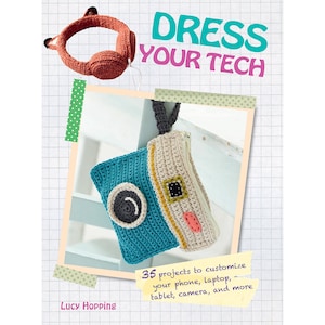 May include: A book cover with the title "Dress Your Tech" and a crocheted camera case. The book cover is decorated with a red and white polka dot pattern and a green and white polka dot pattern. The book cover also features a crocheted headphone design. The book cover text reads "35 projects to customize your phone, laptop, tablet, camera, and more".