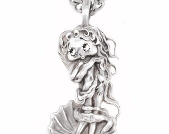 Può includere: Una collana con pendente argentato raffigurante una figura stilizzata di donna con lunghi capelli fluenti. Il pendente è sospeso a una catena ed è ambientato su uno sfondo bianco. La figura è in una conchiglia.